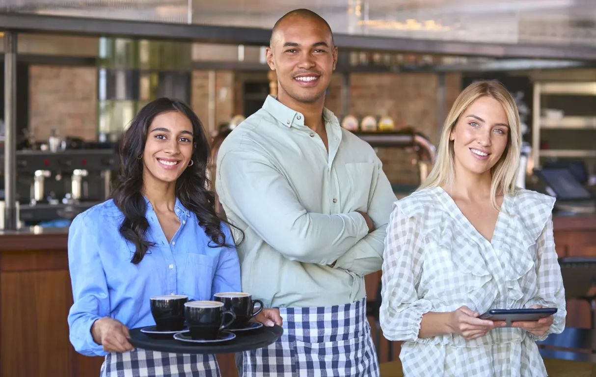 A team of 3 friends standing in a Game Day Grill restaurant