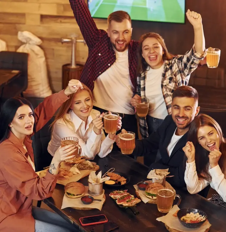 A group of friends cheering and raising their fists in the air.